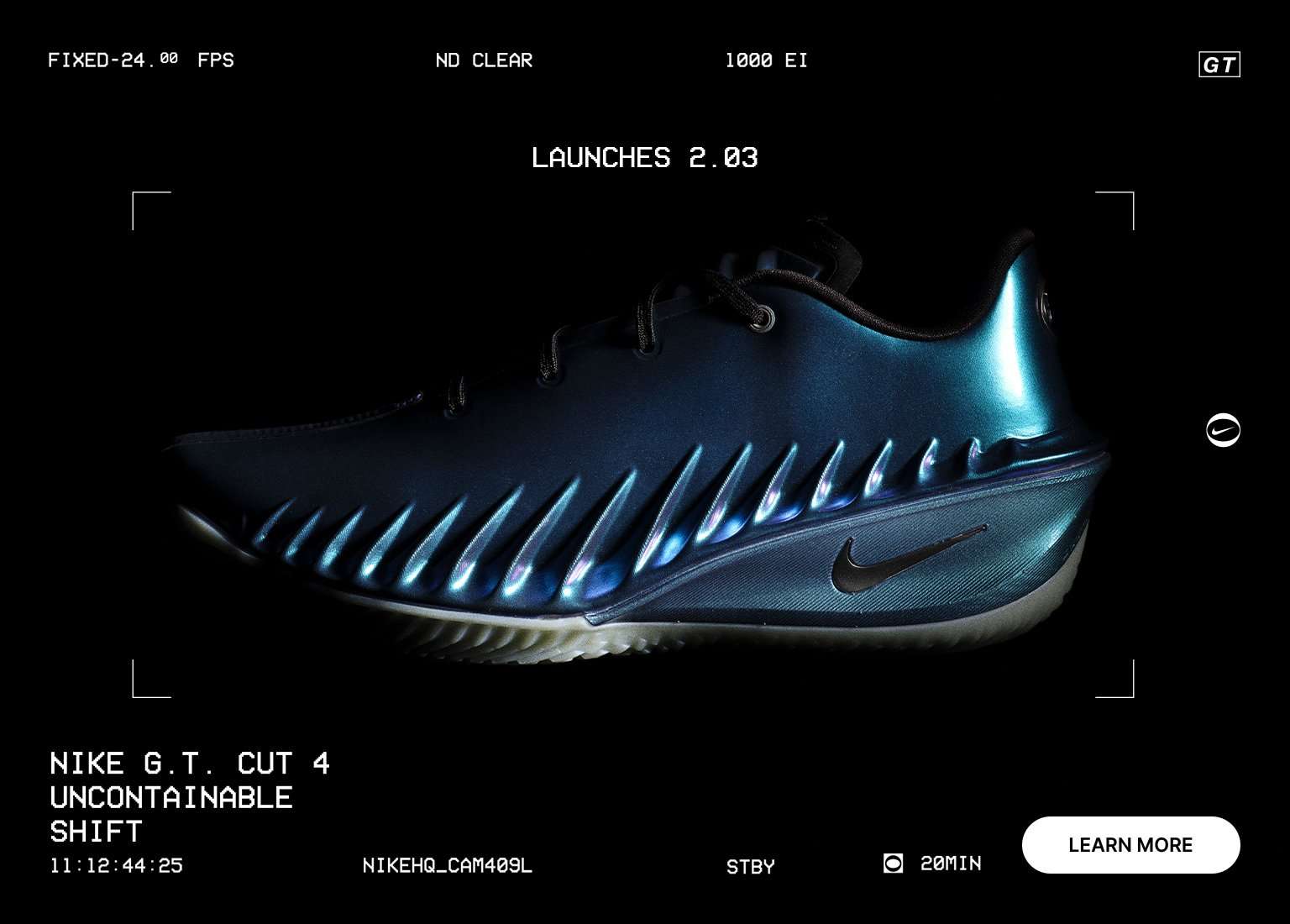 A promotional image for the Nike G.T. Cut 4 Uncontainable Shift basketball shoe, featuring a sleek, iridescent blue-and-teal design with futuristic ribbing along the side. The shoe is centered against a black background styled like a digital camera viewfinder, with text indicating a launch date of 2.03.