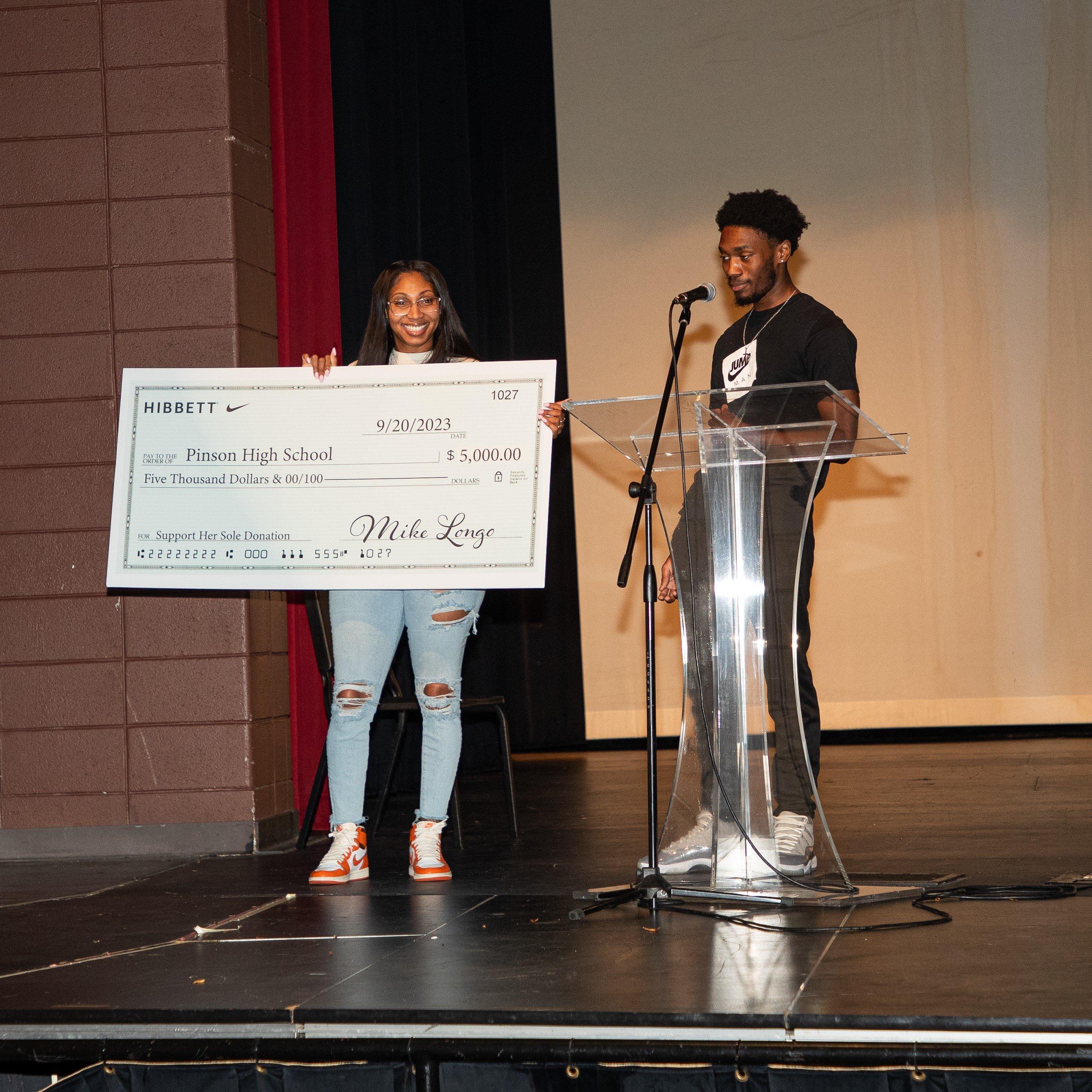 Hibbett store representatives presenting $5000 Support Her Sole donation check