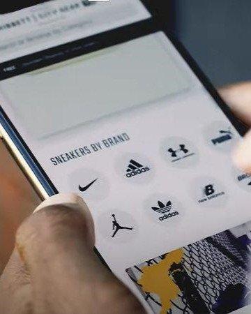 Person holding a phone with Hibbett.com displayed