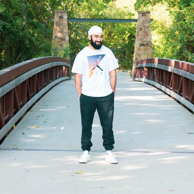 Inder posing in center of bridge entrance in park