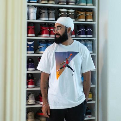 Inder posing in front of his Jordan sneaker closet