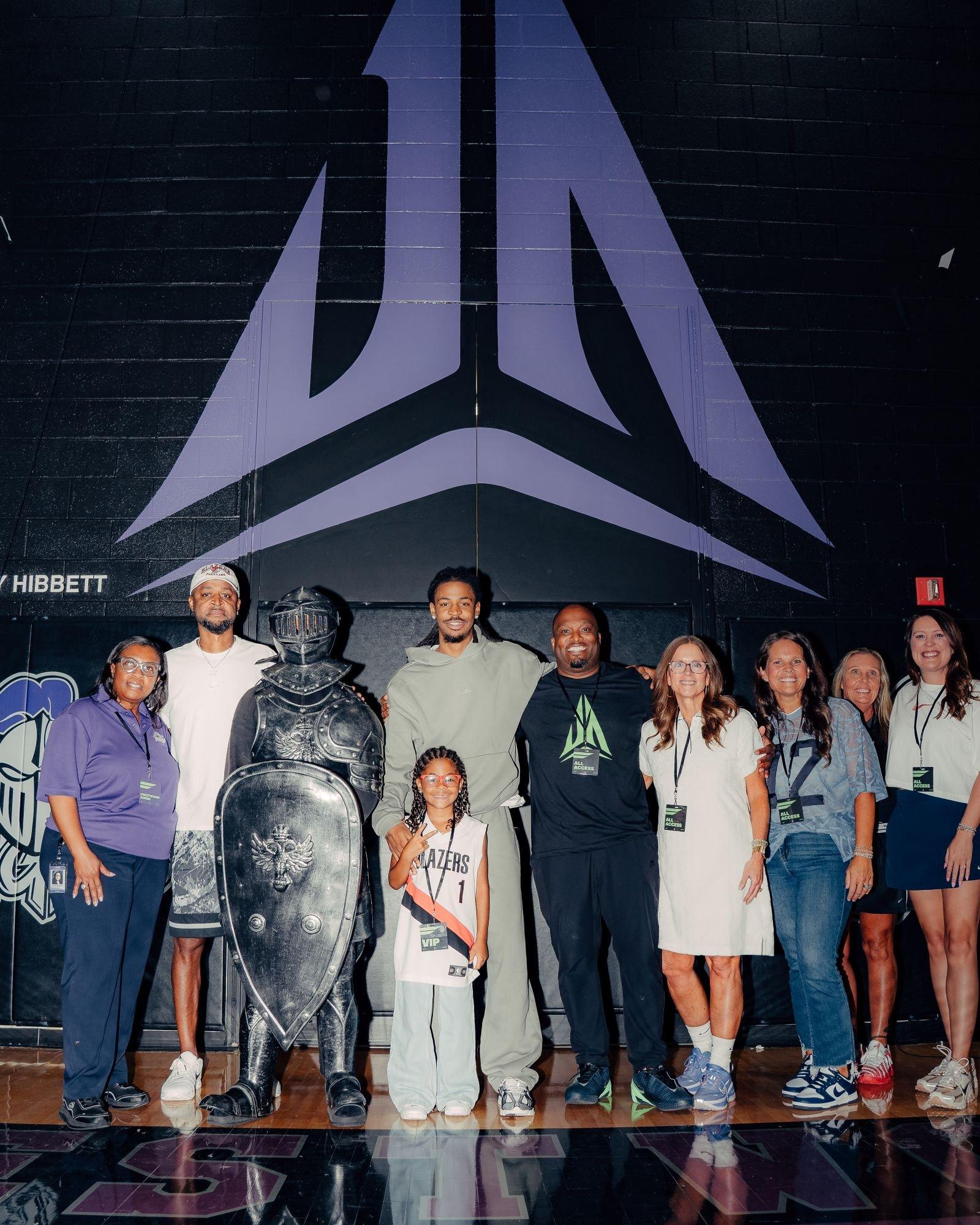 Group photo beneath a Ja Morant logo mural at Crestwood High School during Hibbett and Nike's "Don't Sleep on Sumter" community celebration.