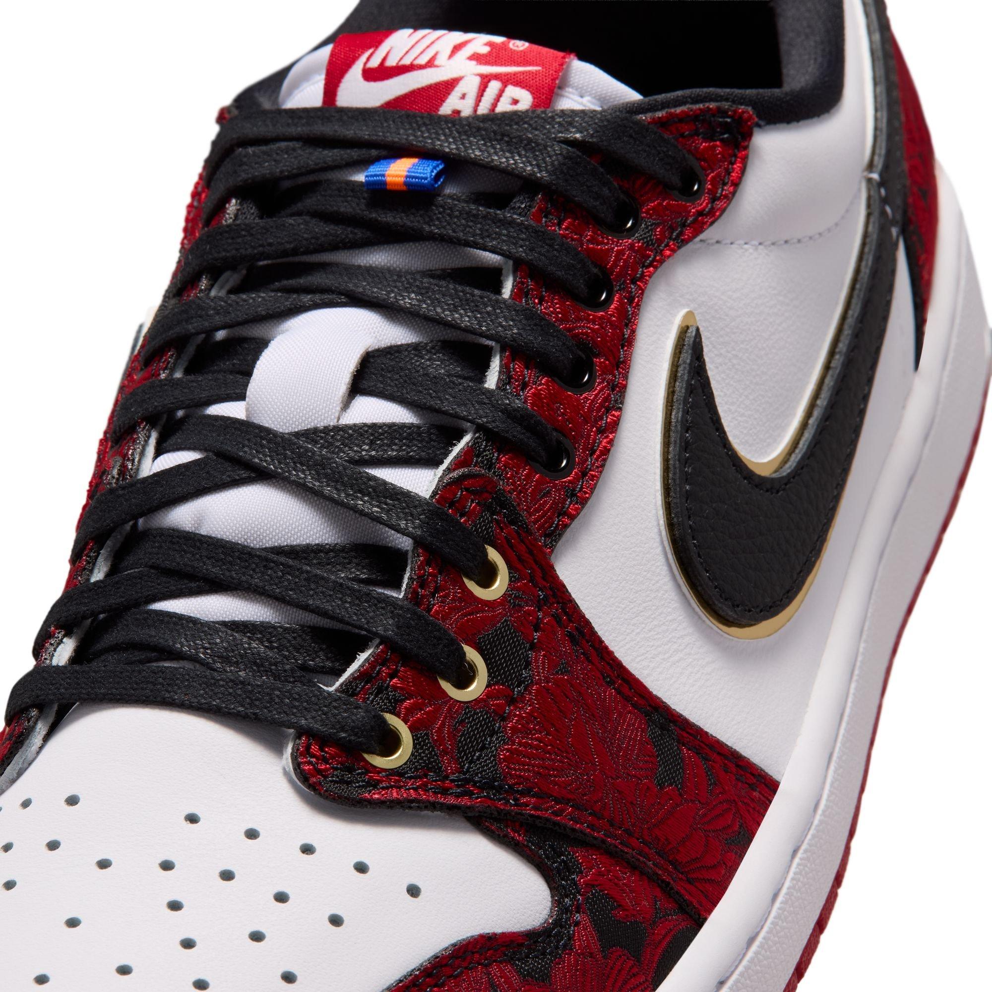 Close-up of the Air Jordan 1 Retro Low OG Garden sneaker featuring black laces, gold eyelets, white leather and red-and-black floral overlays.