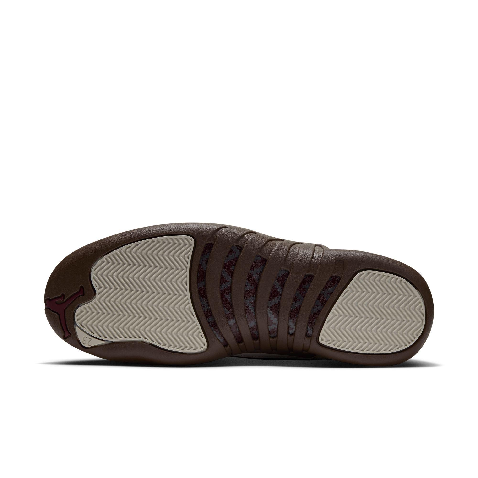 Bottom view of the Jordan 12 Retro &ldquo;Fireside&rdquo; with a brown outsole, cream herringbone traction pods, patterned midfoot details, and a Jumpman logo.
