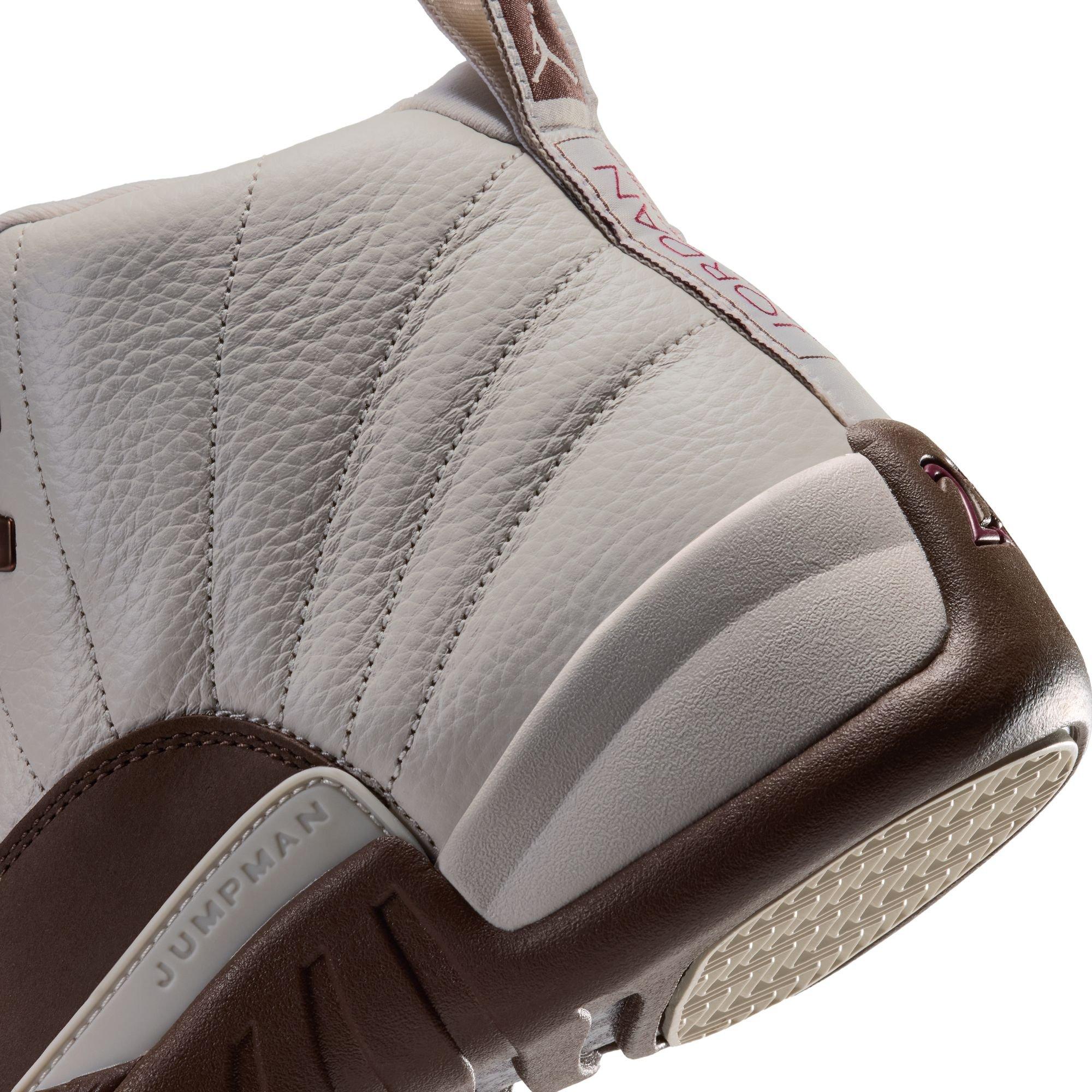 Close-up of the Jordan 12 Retro &ldquo;Fireside&rdquo; showing the cream leather upper, stitched panels, brown heel, sculpted midsole, and branded pull tab.