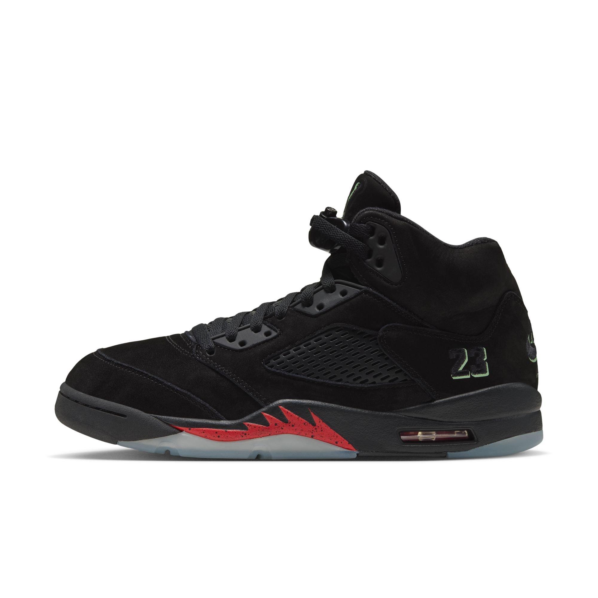 Side view of the Air Jordan 5 Retro Halloween sneaker featuring a black suede upper, black mesh panels, green &ldquo;23&rdquo; embroidery, red midsole accents and an icy translucent outsole.