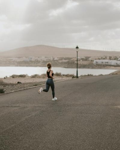 Examining Your Gait - Woman Running Near Lake on Road