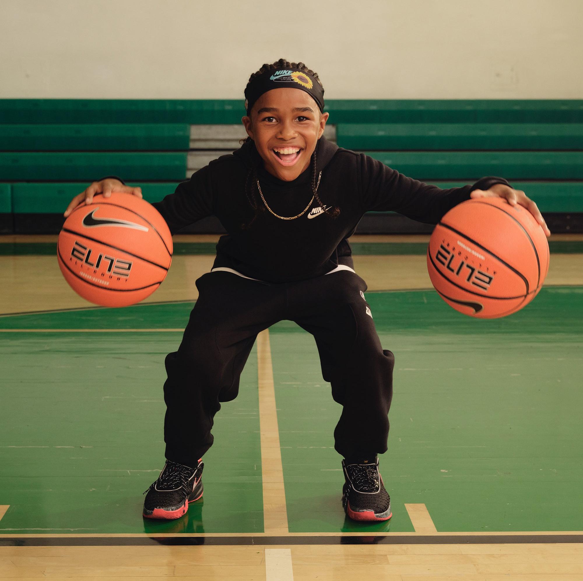 Nike LeBron 20 "​Miami Heat" kid bouncing two basketballs