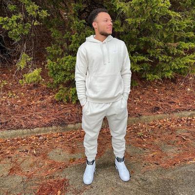 Man wearing toe-to-head creme/beige Nike joggers and hoodie