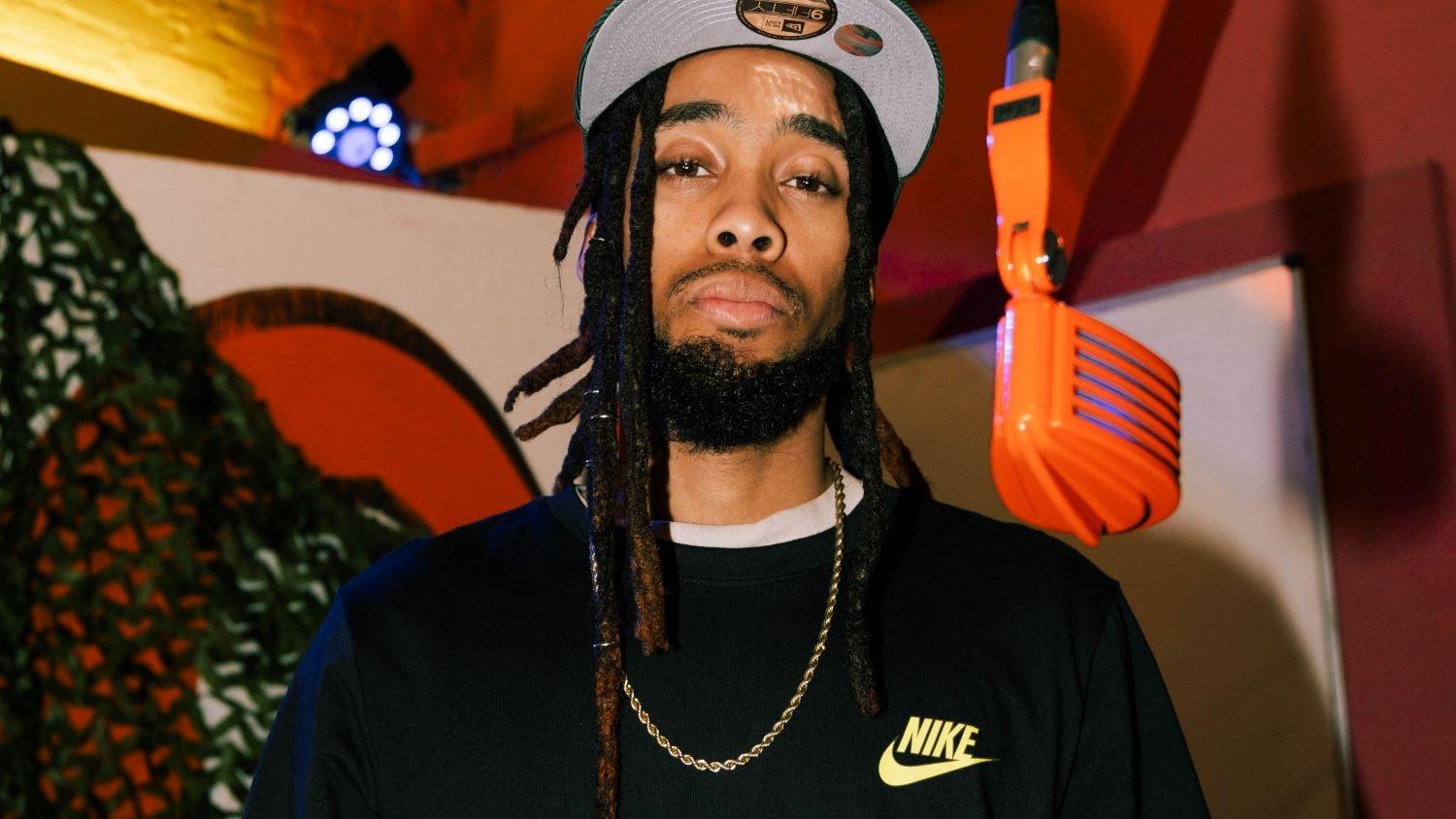 "Mvstermind" Austin posing in studio with orange mic