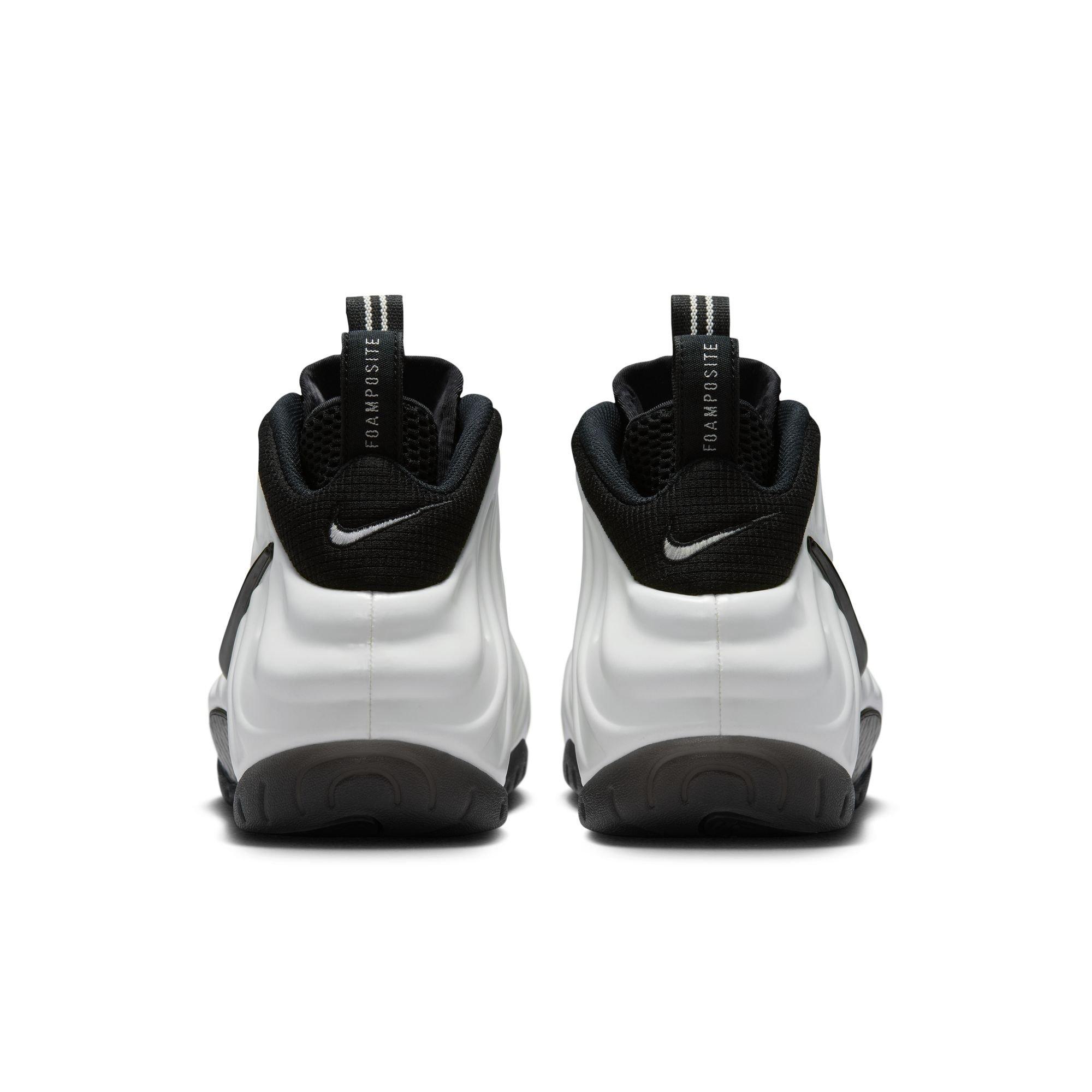 Rear view of Nike Air Foamposite Pro Premium sneakers featuring white molded uppers, black collars, embroidered Swooshes and striped pull tabs.