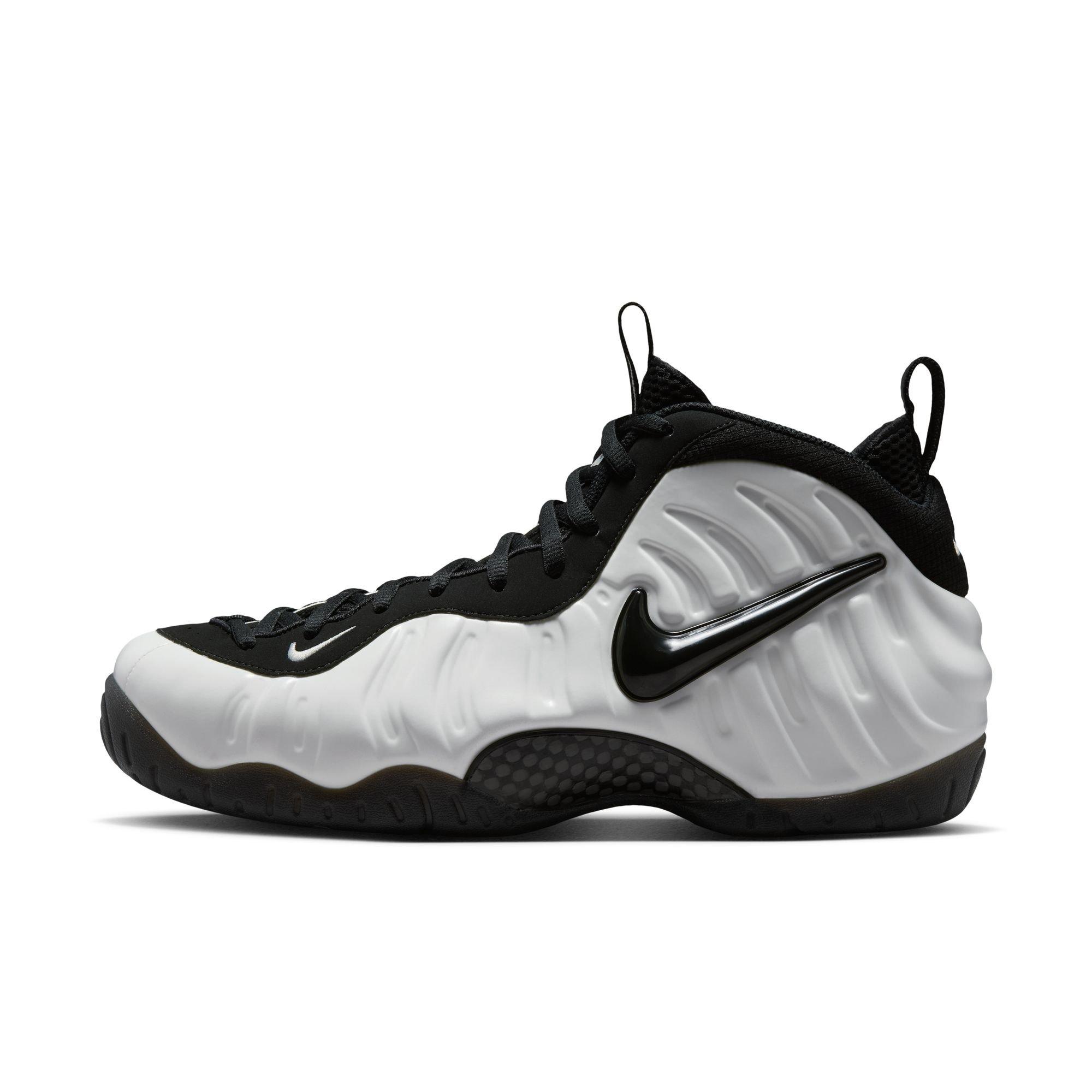 Side view of the Nike Air Foamposite Pro Premium sneaker featuring a white molded upper, black laces, a glossy black Swoosh and black outsole.