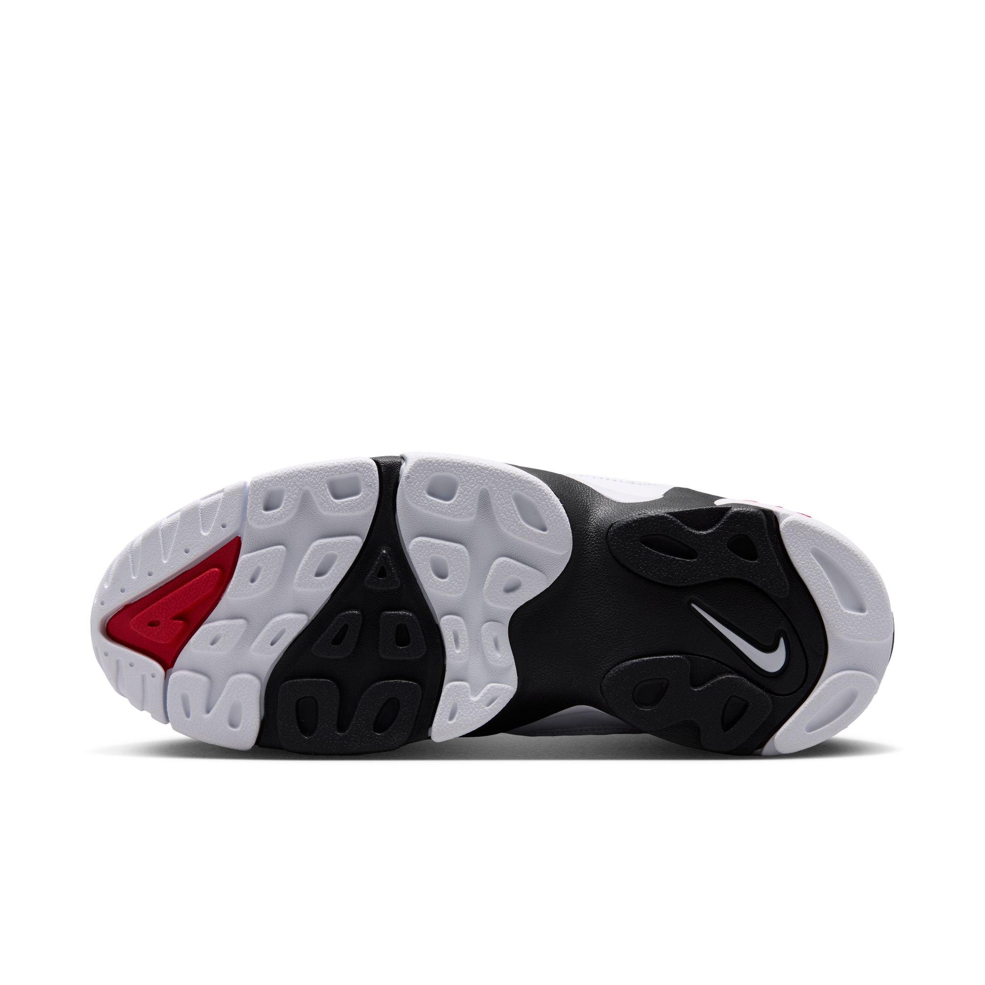 Bottom view of the Nike Air Diamond Turf II showing a segmented black-and-white rubber outsole with red accents and a white Nike Swoosh.