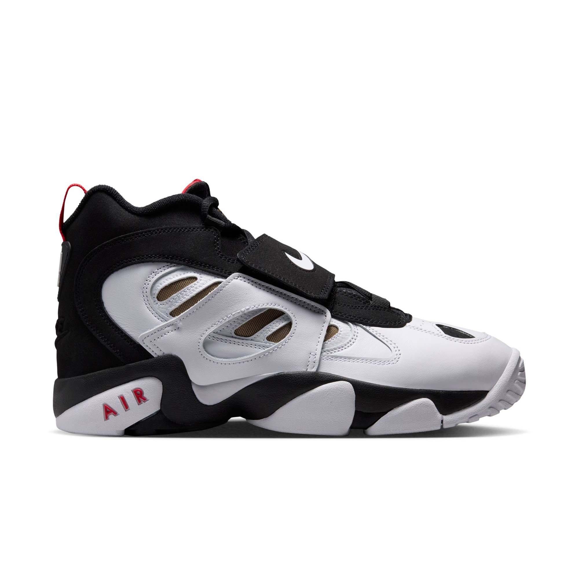 Side view of the Nike Air Diamond Turf II sneaker with a white leather upper, black overlays, gold mesh panels, red accents and a black midfoot strap.