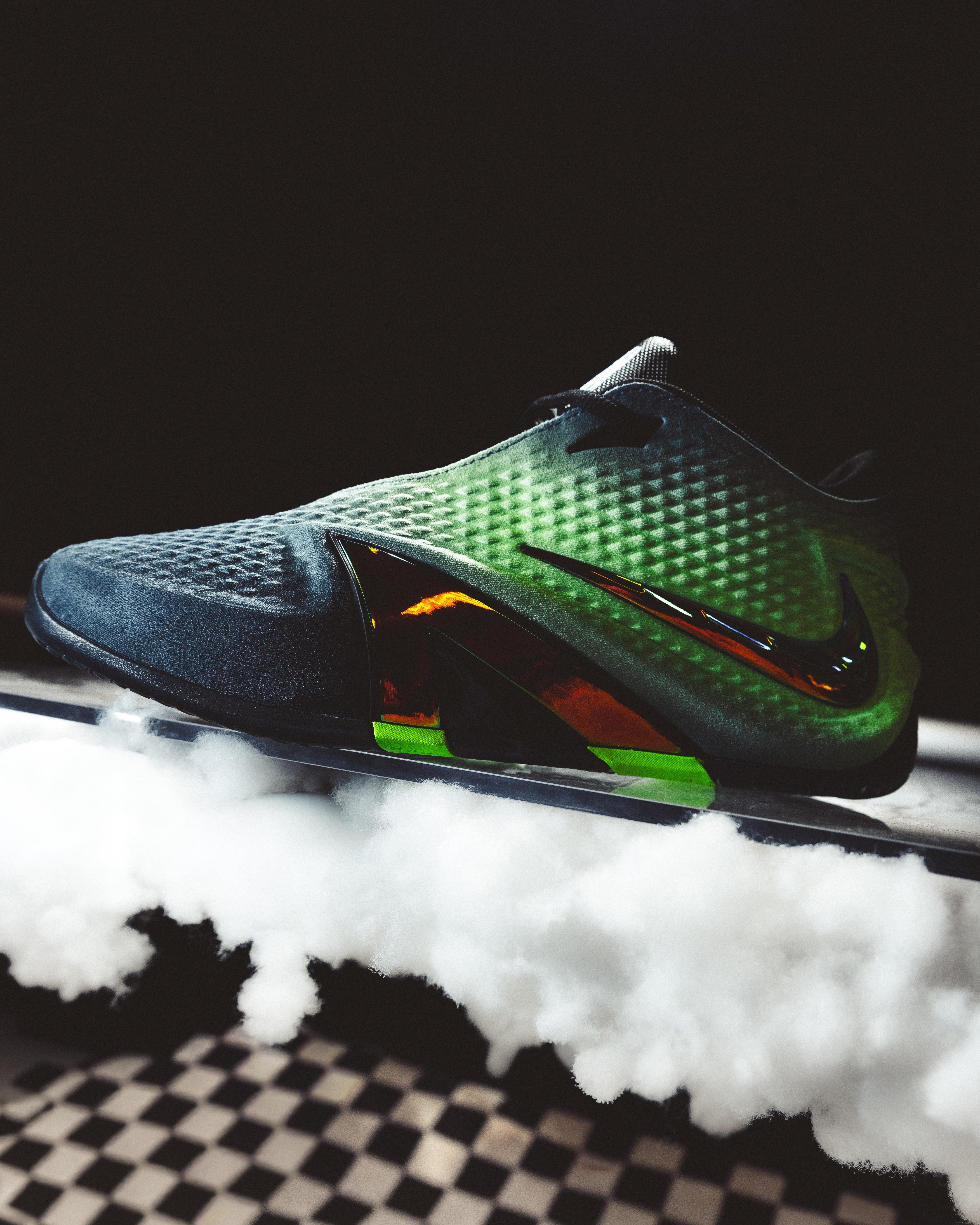Side view of the Nike Ja 4 Nightmare basketball shoe with a green and black textured upper, iridescent Swoosh, translucent orange midfoot panel and neon green outsole accents.