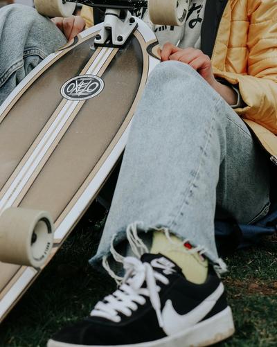 Man sitting down holding skateboard wearing Nike SB shoes