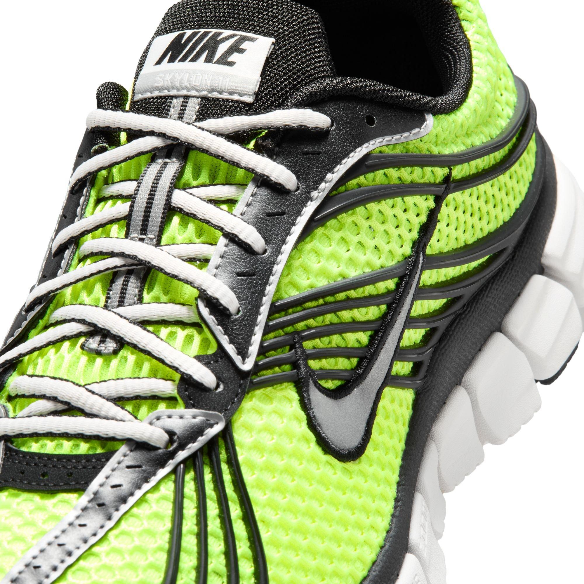 Close-up of the Nike Zoom Skylon 11 Volt sneaker showing white laces, black overlays, bright green mesh and a black Nike Swoosh.