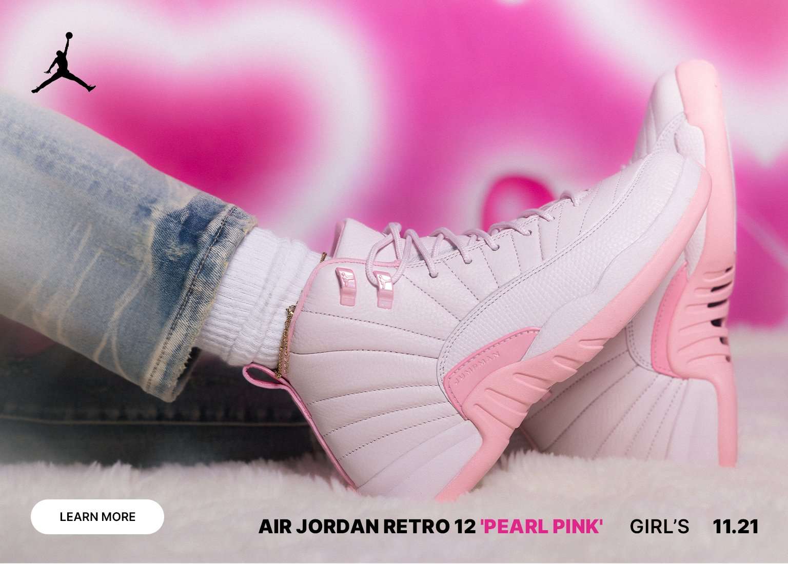 A promotional image for the Air Jordan Retro 12 'Pearl Pink' shoes, showing two pairs of the pink and white sneakers. The background is bright pink with hearts and a smiling young girl wearing one pair. The Jordan Jumpman logo is in the top left.