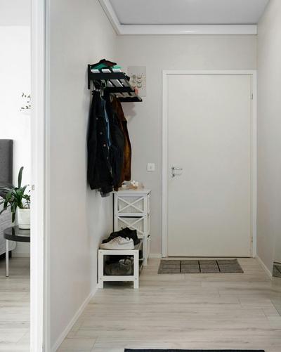 Picture of an entry way with a bench that has sneakers on it.