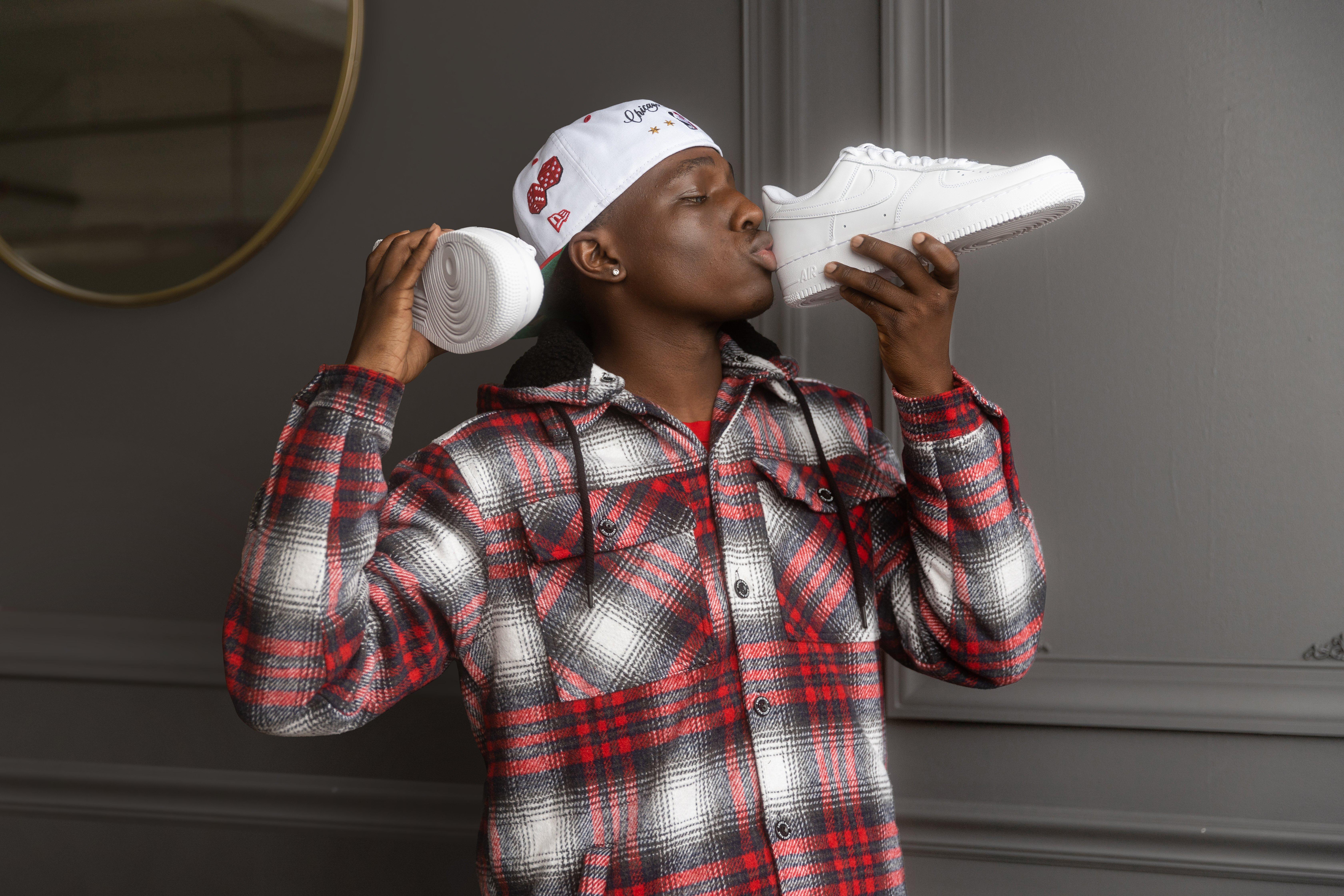 Man kissing the heel of a white/white Nike Air Force Ones