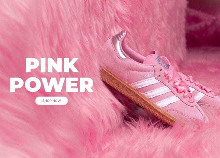 Pink adidas Samba sneakers on a pink faux fur background.
