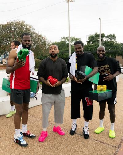 Group of participants standing outdoors holding Nike KD shoeboxes and colorful KD 19 basketball shoes during a community basketball event.