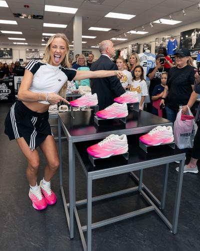 sophie-cunningham-posing-with-table-of-crazy-energy-pe-shoes-at-hibbett-event