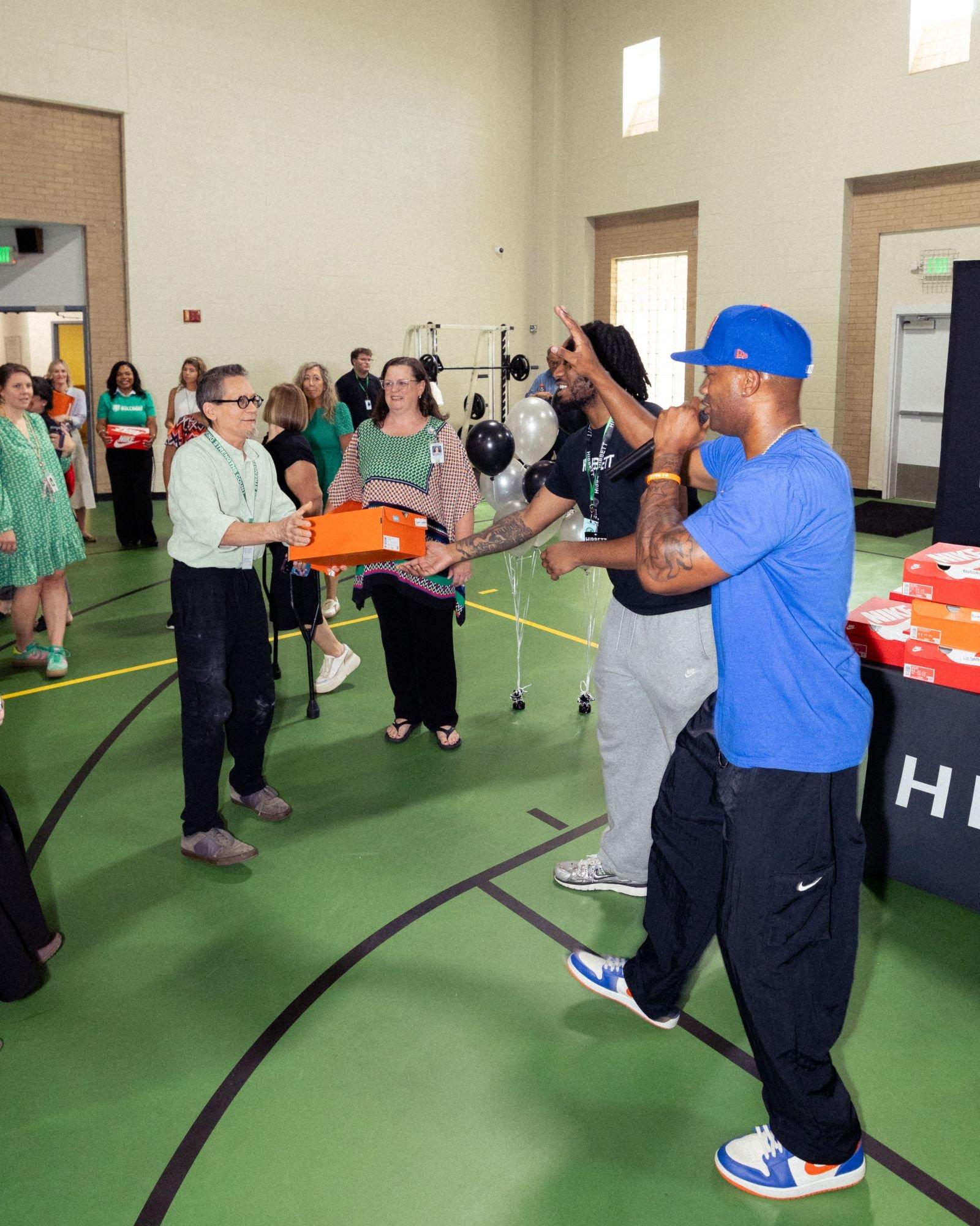 Spring Valley School staff members receive Nike shoe boxes during a Hibbett and Nike celebration event.
