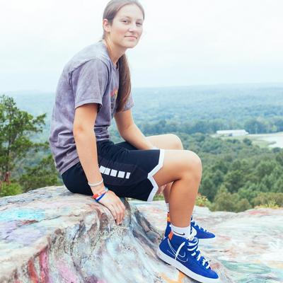 Chelsea sitting on rock near edge of lookout cliff