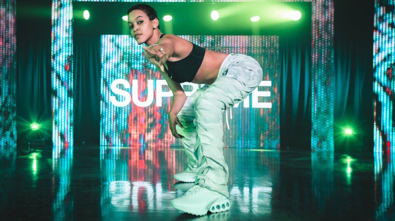 Supreme posing with gaming controller while wearing Air Max Dn sneakers for women