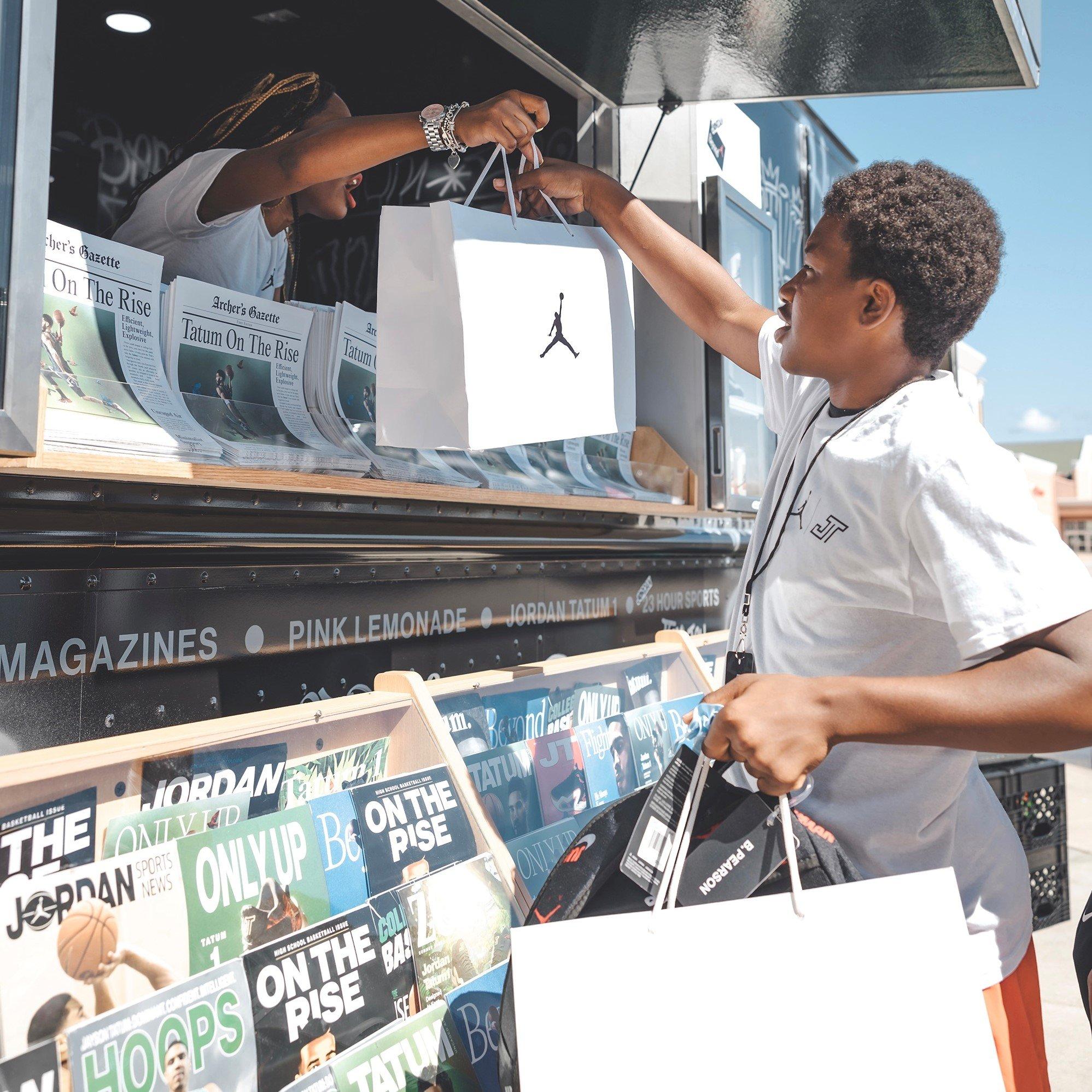 Kid outside receiving a Jordan gift from the Tatum Truck
