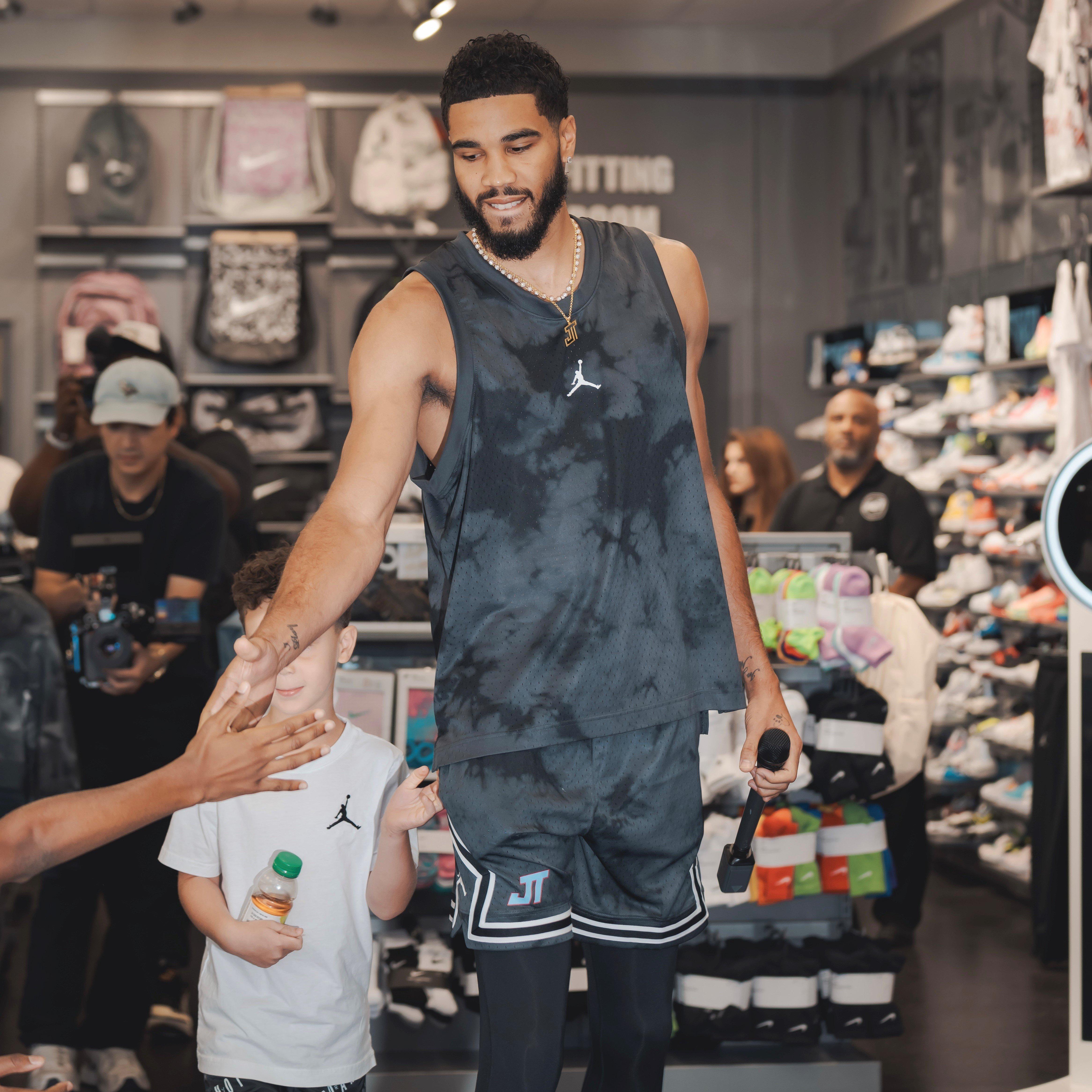 Jasyon Tatum and Deuce slapping hands with event guest