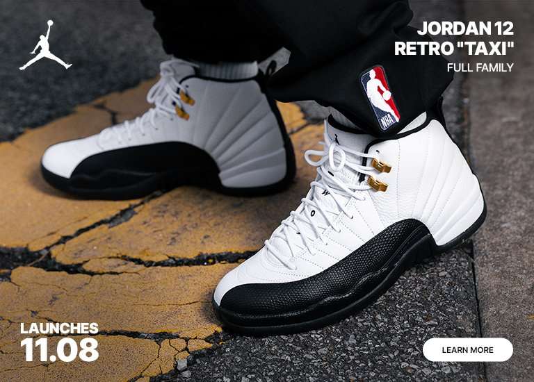 Jordan 12 Retro Taxi sneaker launch banner. Close-ups of the white and black shoes with gold accents, and a full shot of a person wearing them with a black Bulls sweatsuit. Launches 11.08.