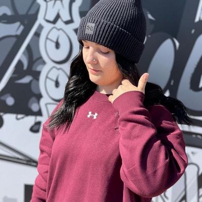 Woman wearing maroon Under Armour pullover and black beanie