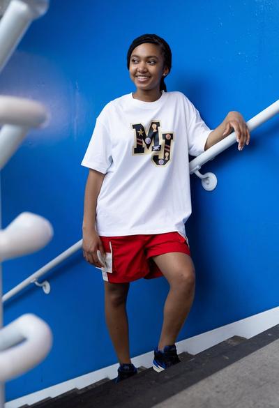 Woman wearing red shorts with white Jordan graphic tee