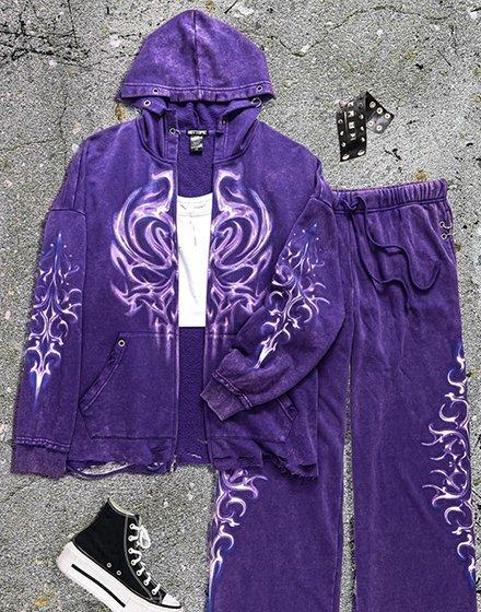 Purple hoodie and sweatpants set with flame graphics, shown with sneakers and studded belt. Shop Now.