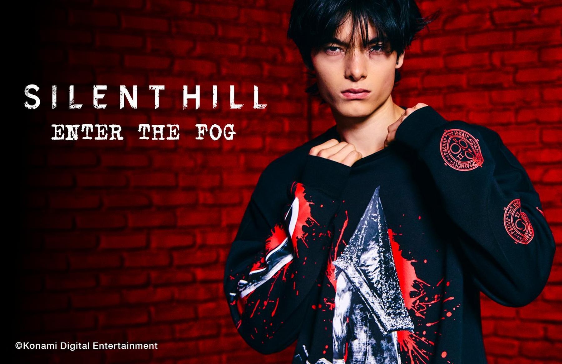 Model wearing Silent Hill “Enter the Fog” sweatshirt with character graphic and sleeve patches. Shop Now.