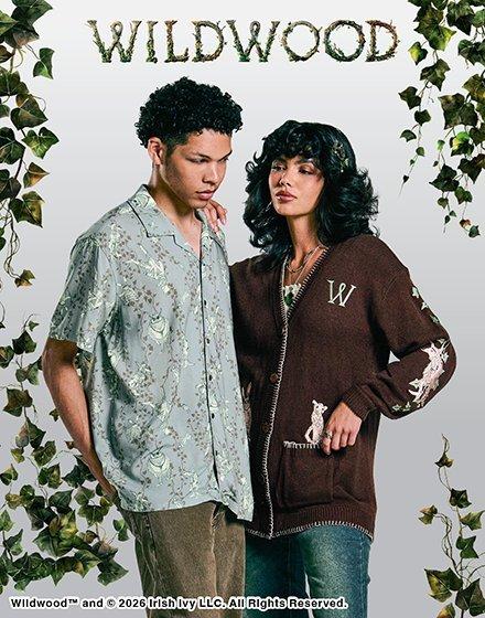 Two models posing in Wildwood apparel, with “W” cardigan and patterned short-sleeve shirt. Shop Now.