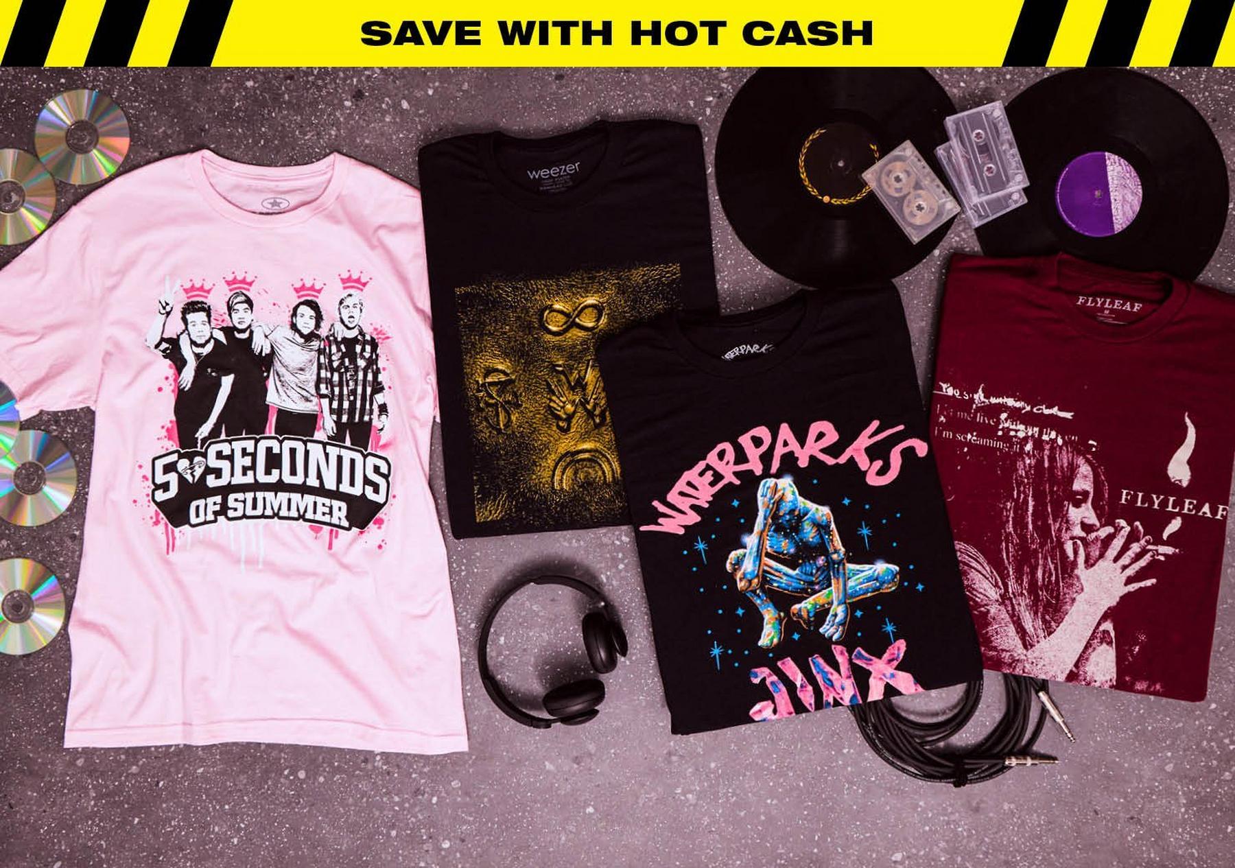 Band graphic T-shirts laid out with vinyl records, cassette tapes, CDs, headphones, and audio cable. Shop Now.