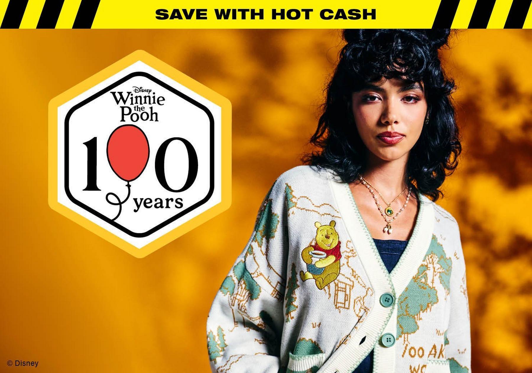Model wearing Disney Winnie the Pooh cardigan with 100 years logo and “SAVE WITH HOT CASH” text. Shop Now.