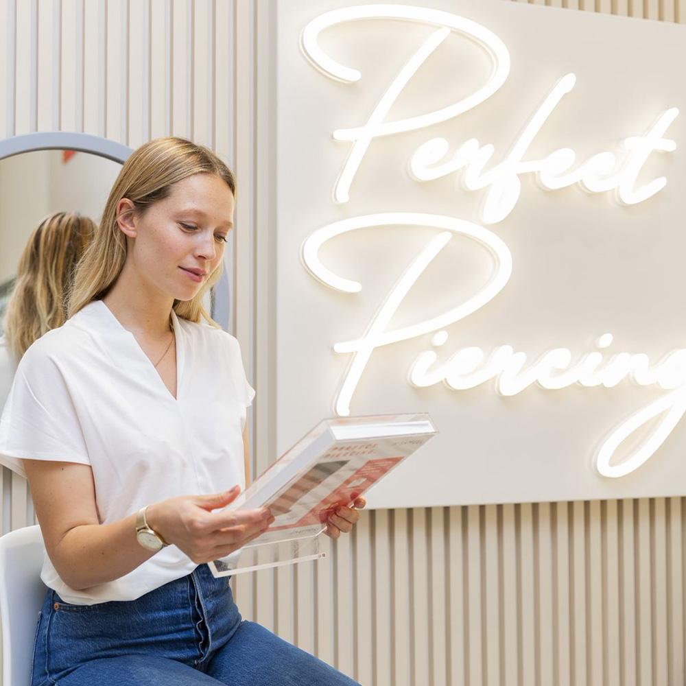 Woman getting her ears pierced at the Perfect Piercing Studio in H.Samuel