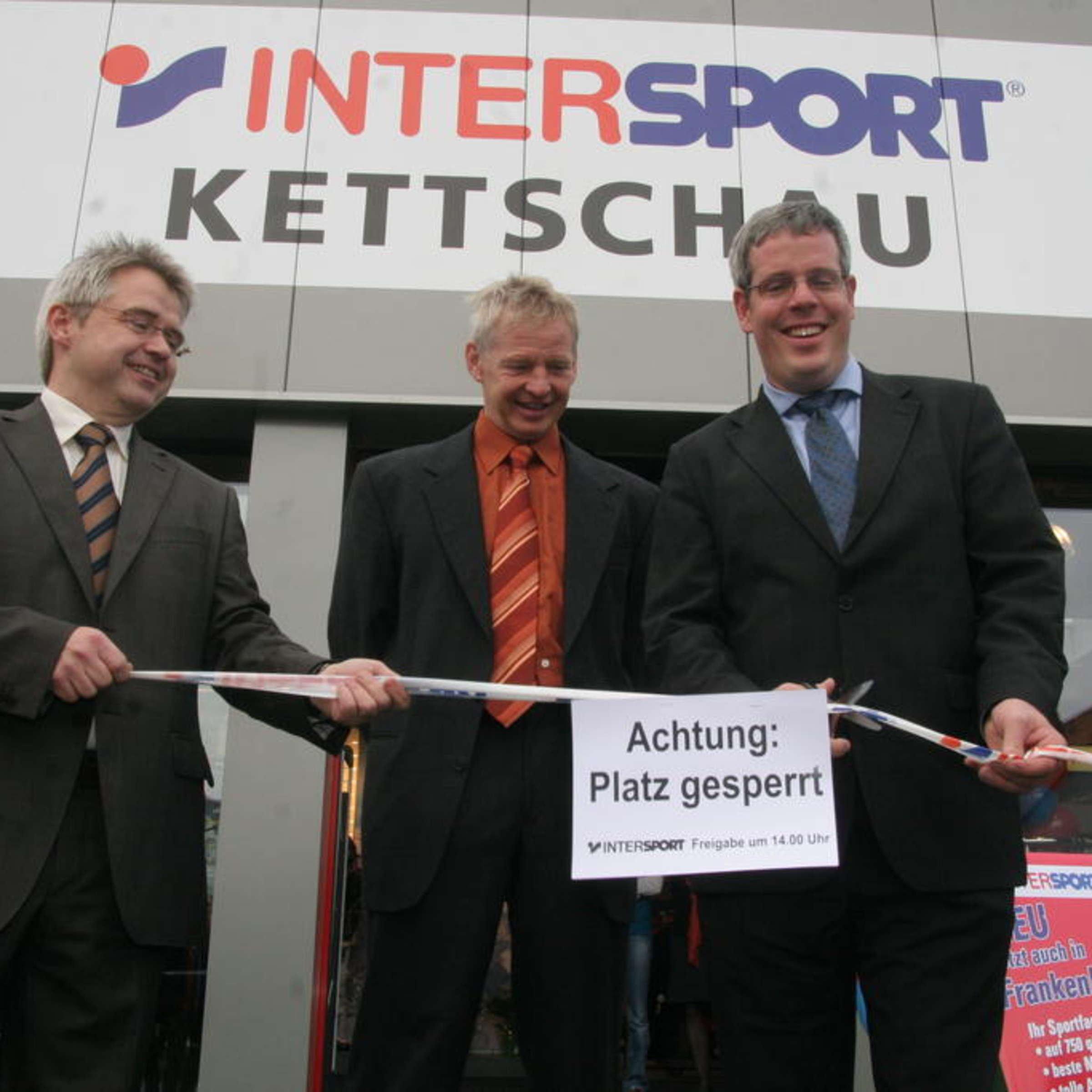 Drei Menschen eröffnen das Geschäft INTERSPORT Kettschau.