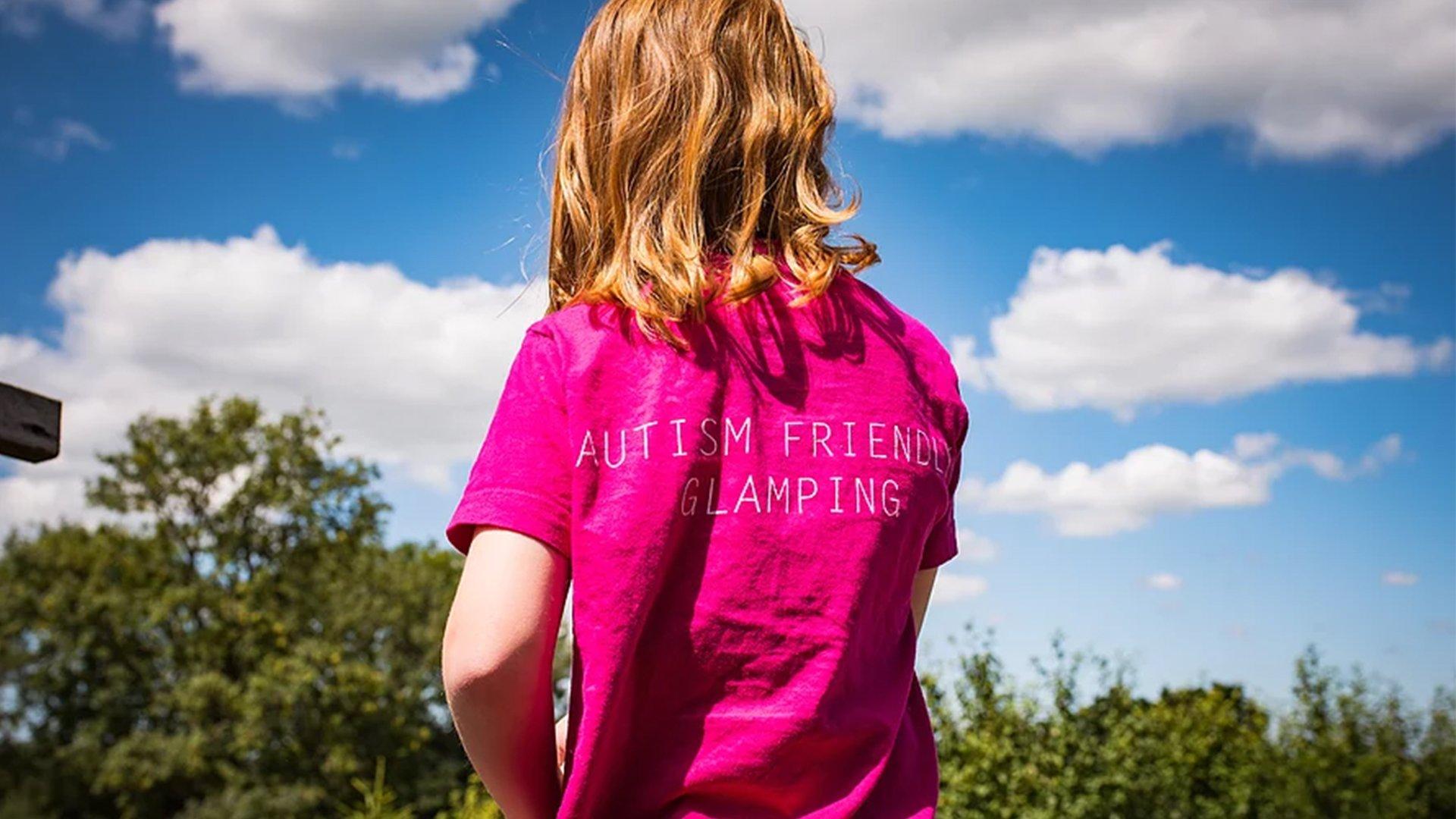 Image of a child wearing a t-shirt that promotes autism friendly camping at Leafy Fields Campsite