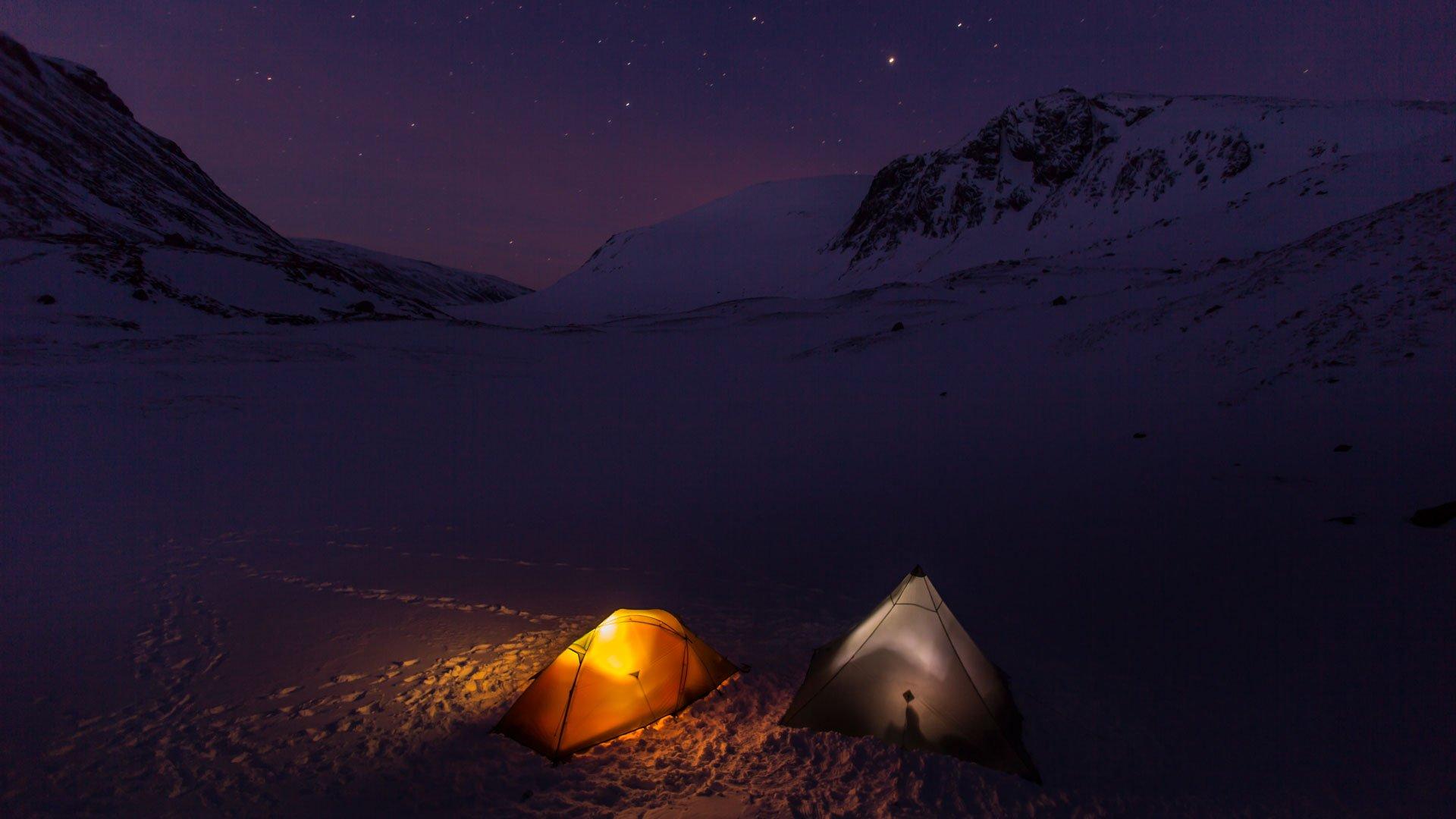 Awild camping at night with tents lit up