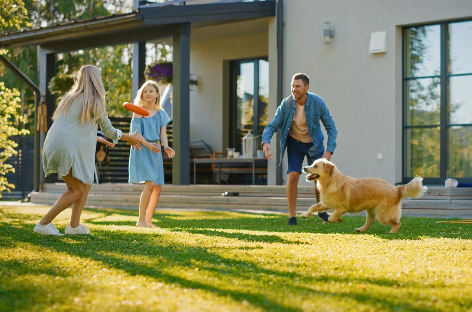 family playing in the garden with a dog and frisbee