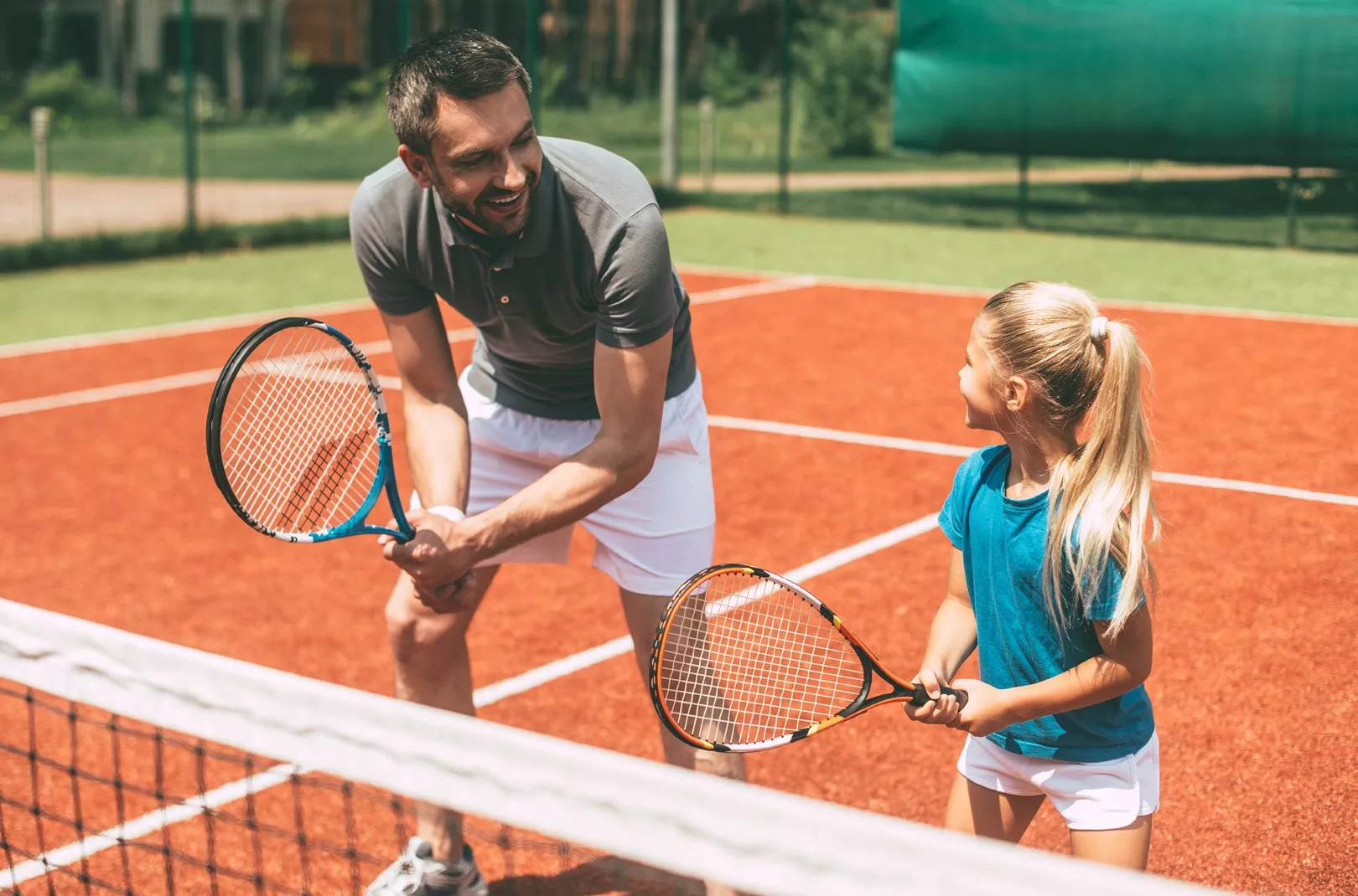 father and daughter playing tennis