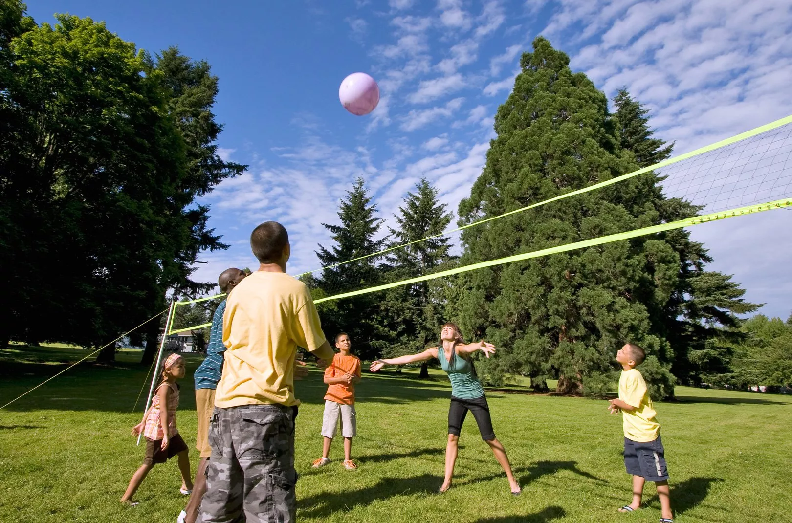 family playing volleyball at the park