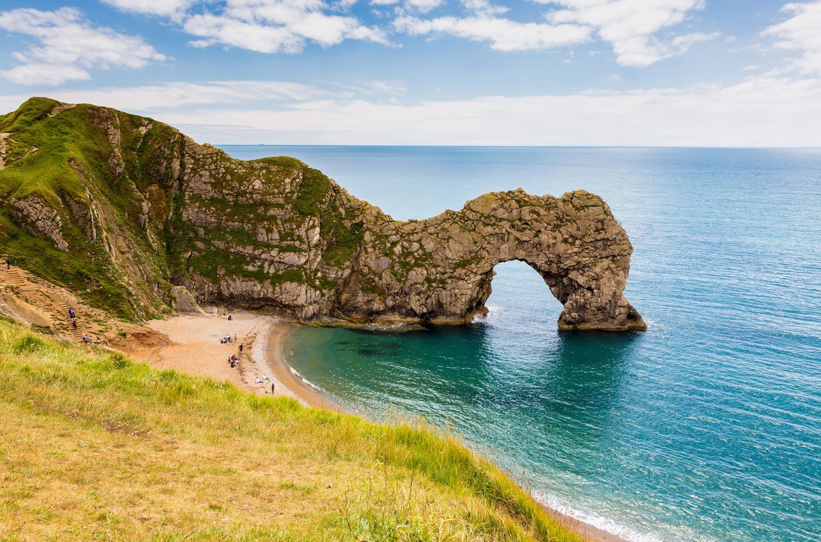 Scenic view of Durdle Door, an iconic rock arch on a sandy beach along the Jurassic Coast in Dorset, England
