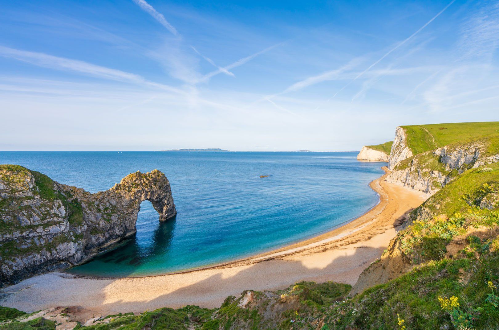 Scenic overhead view of Durdle Door, an iconic rock arch on a sandy beach along the Jurassic Coast in Dorset, England