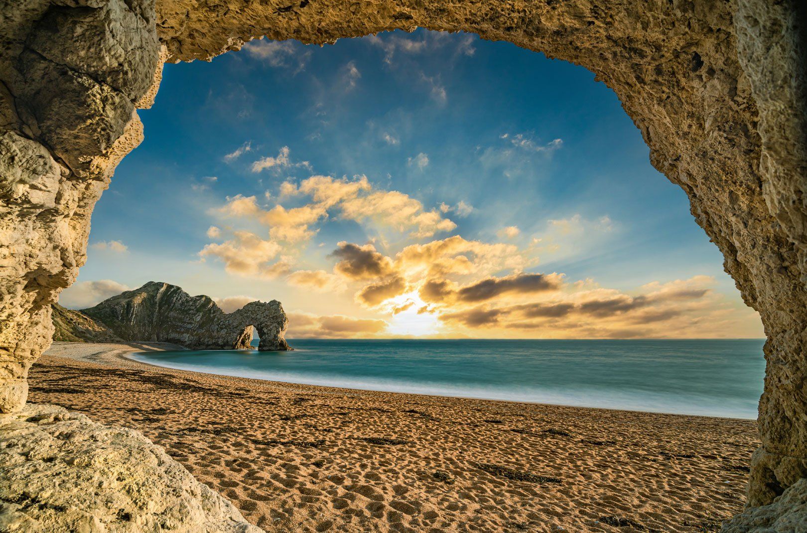 Scenic view of Durdle Door, an iconic rock arch on a sandy beach along the Jurassic Coast in Dorset, England